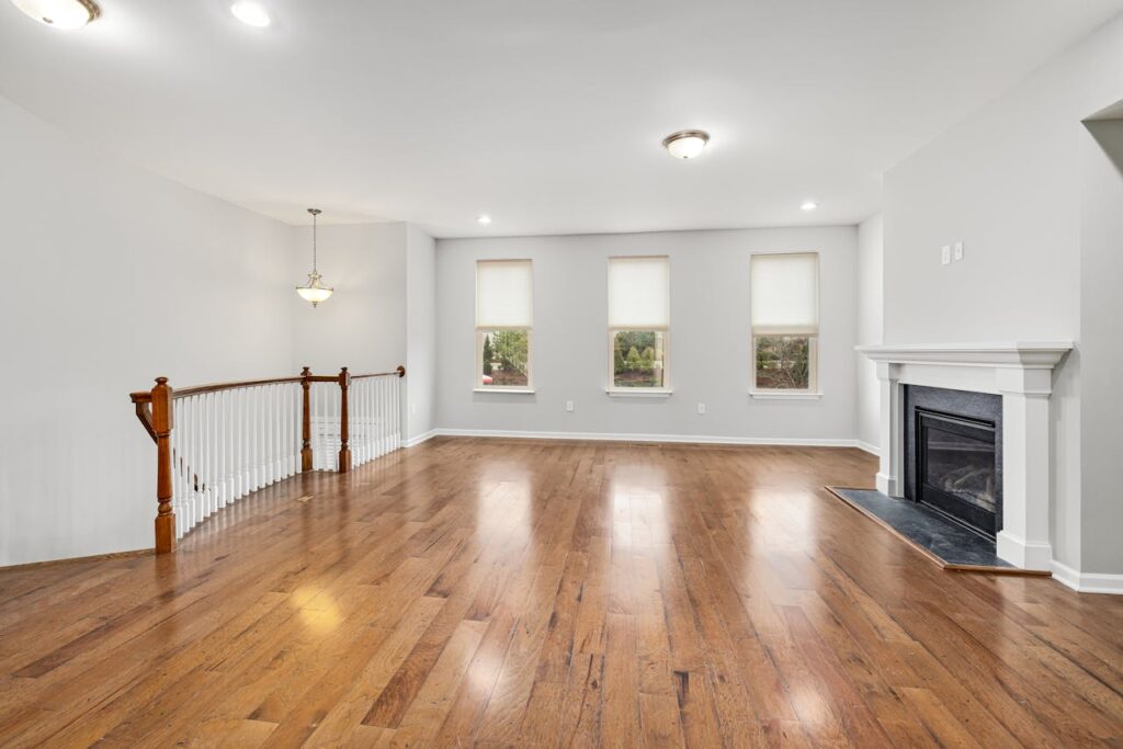 pexels-photo-15409437 Bright and spacious modern living room with wooden floors and a fireplace, perfect for interior design inspiration.